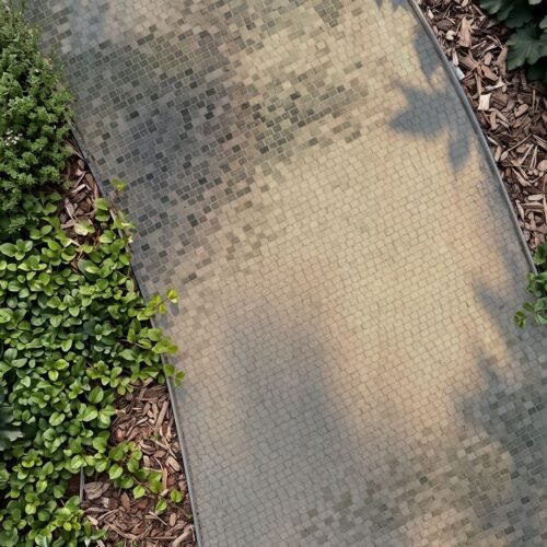 Overhead view of a stone mosaic walkway path in sage and sand tones curving between garden beds.