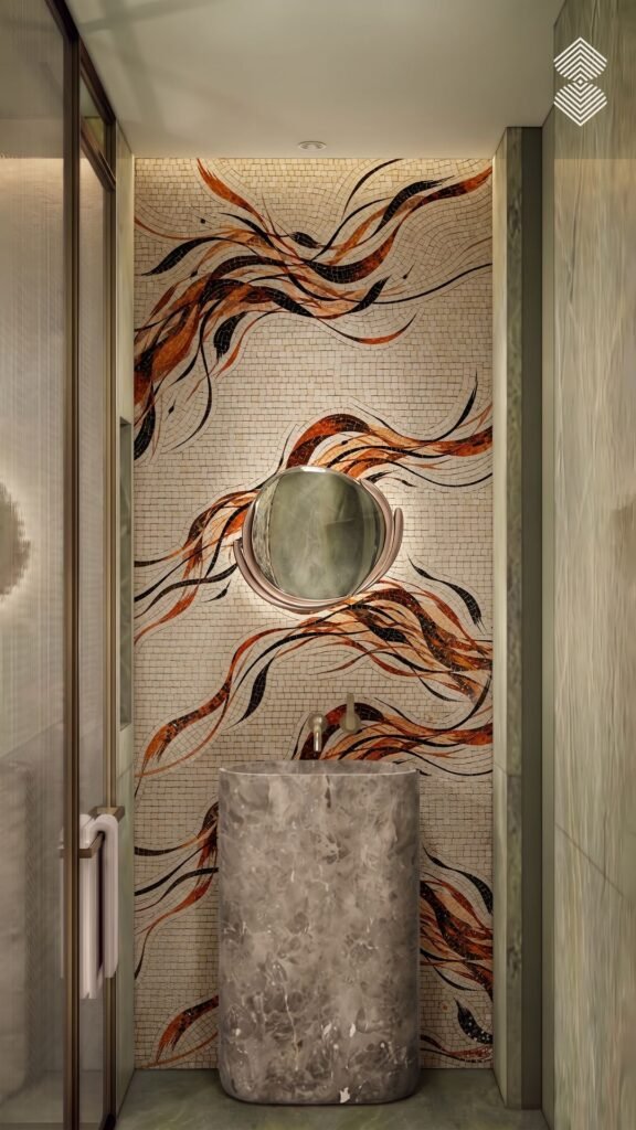 A powder room featuring a cylindrical grey marble sink and a round mirror mounted on a mosaic tiled feature wall showing flowing amber, brown, and black ribbons on a cream background.