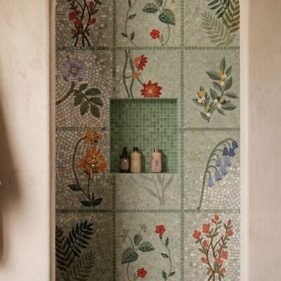 A botanical grid mosaic of flowers and leaves installed as a shower wall panel.