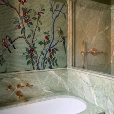 A chinoiserie bird mosaic mural on a sage green wall shows songbirds perched among berry branches and blossoms.