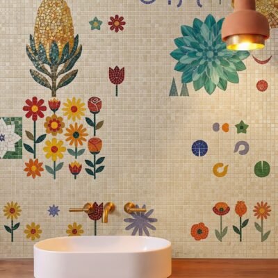 A folk flower bathroom mosaic of scattered mosaic daisies, tulips and a protea on a cream tiled wall above a sink.