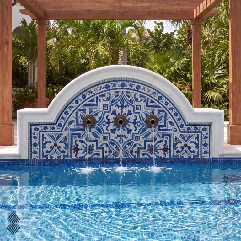 An arched Moroccan mosaic fountain panel in cobalt blue and white tile mounted above a pool with three bronze spouts.