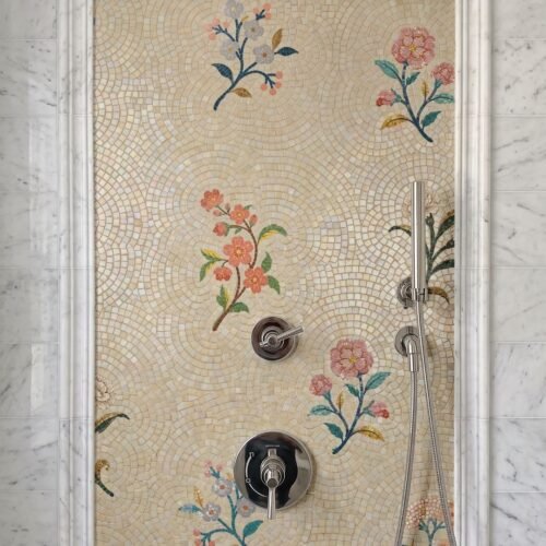 A framed mosaic panel of scattered floral sprigs installed as a shower wall feature.