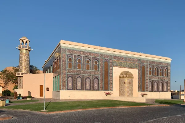 Islamic mosaic wall with geometric patterns, arches, and calligraphy inspired by traditional mosque architecture and heritage design.