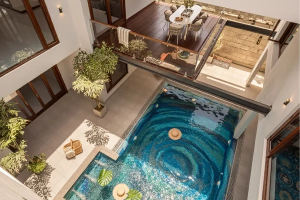 Luxury swimming pool with swirling blue mosaic design inspired by ocean currents, creating a dramatic whirlpool visual effect.