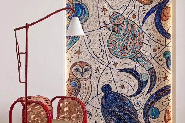 Handcrafted celestial mosaic featuring abstract cosmic motifs, stars, birds, and swirling blue patterns within an illuminated arched niche.